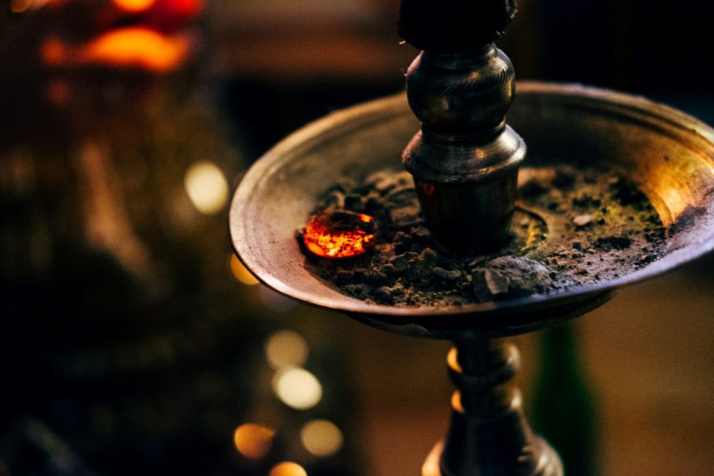 shisha de latón con cenizas de tabaco, una porción aún encendidas