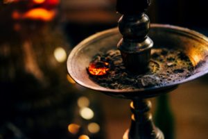 shisha de latón con cenizas de tabaco, una porción aún encendidas